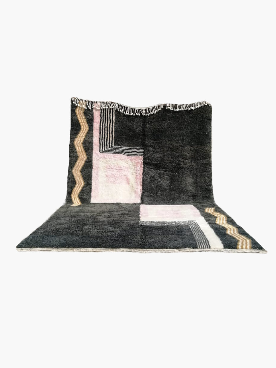 A rectangular, flatweave Berber rug with geometric patterns, primarily in black, gray, and beige tones, with a fringed edge.